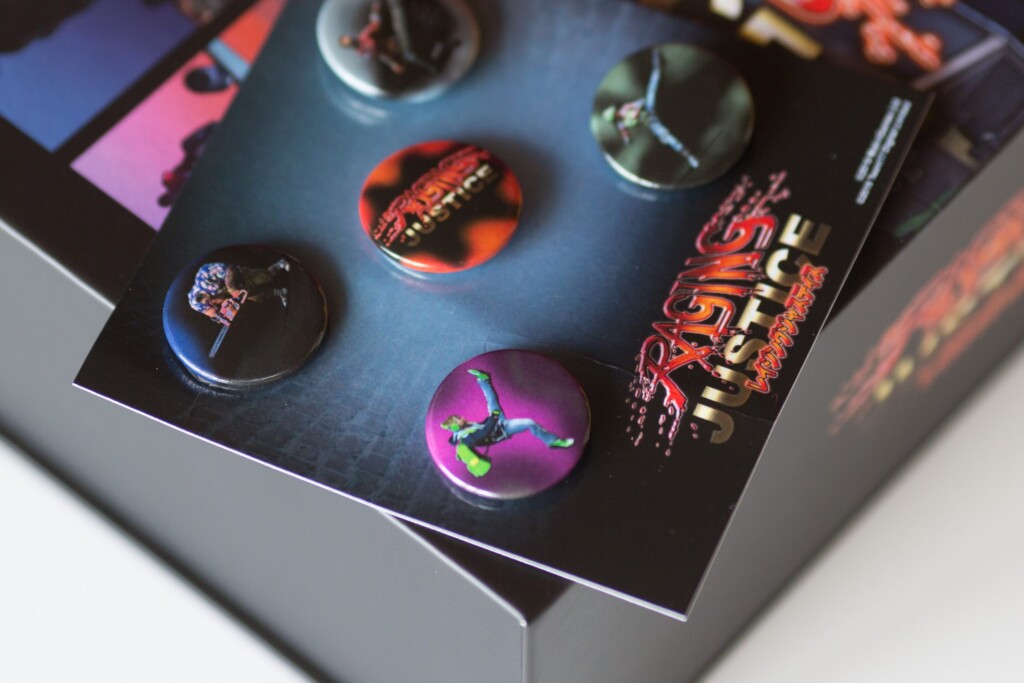 Raging Justice Collection Edition rigid box with five badges featuring artwork on blue background, displayed open.