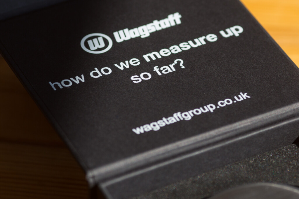 Black Wagstaff branded box with white text reading "how do we measure up so far?" and website URL wagstaffgroup.co.uk