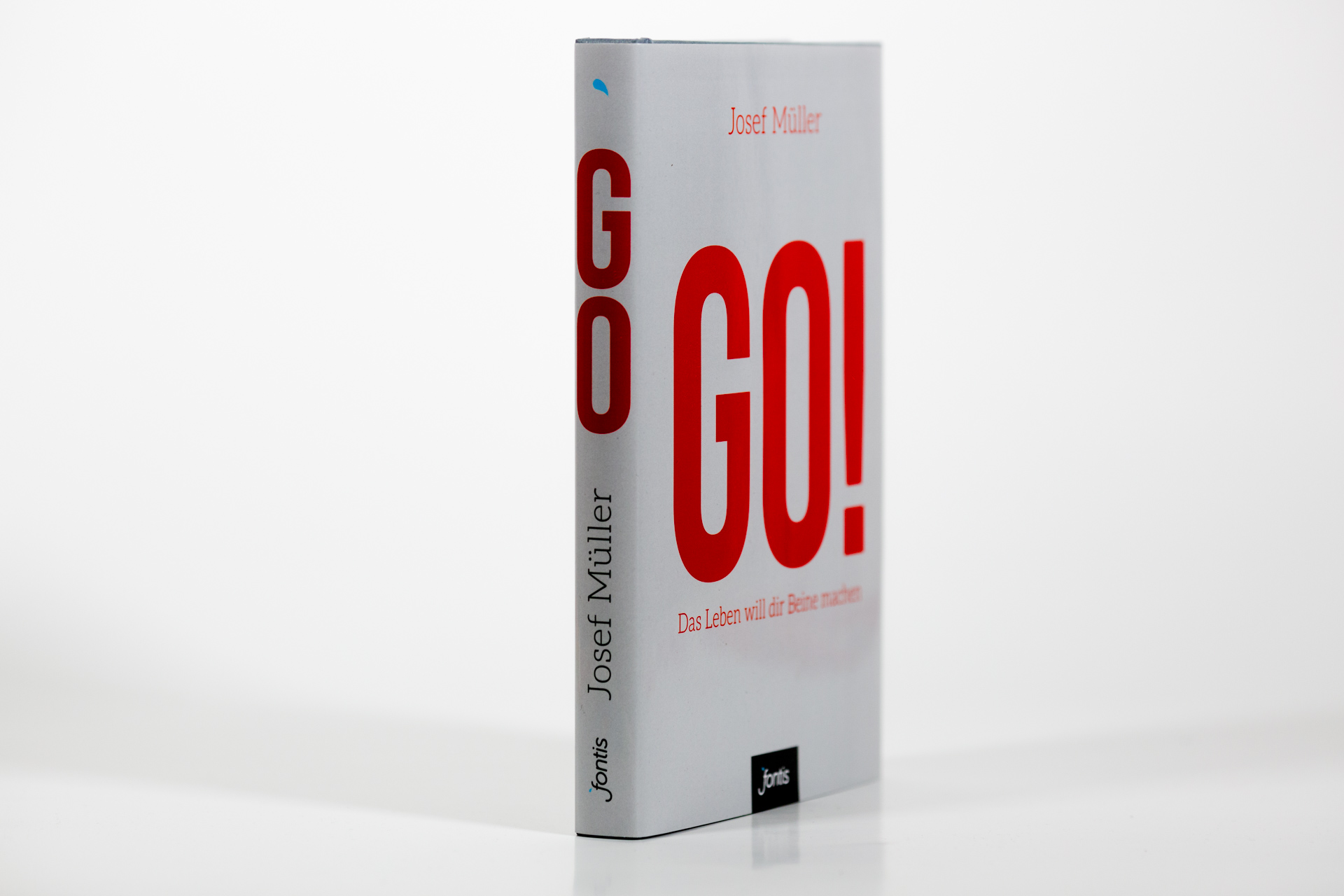 Hardcover book with grey wrapper featuring large red "GO!" lettering and author name Josef Müller on spine.