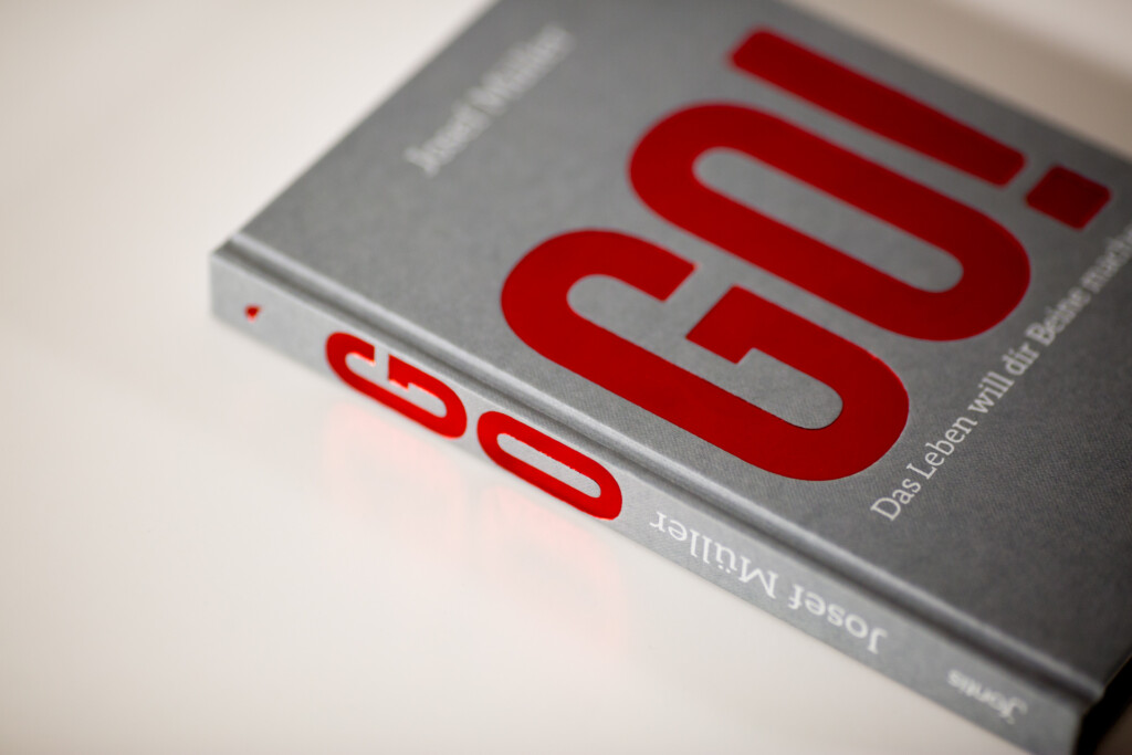 Hardcover book with red foil-stamped cover showing large numerals and grey wrapper.
