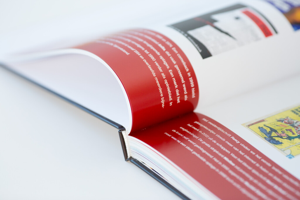 Open catalogue with red text pages and black binding visible in close-up.