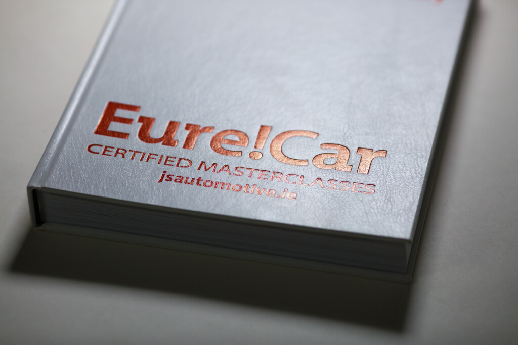Eurecar diary with red foil-stamped cover text on grey board stock, stacked copies showing binding edge.