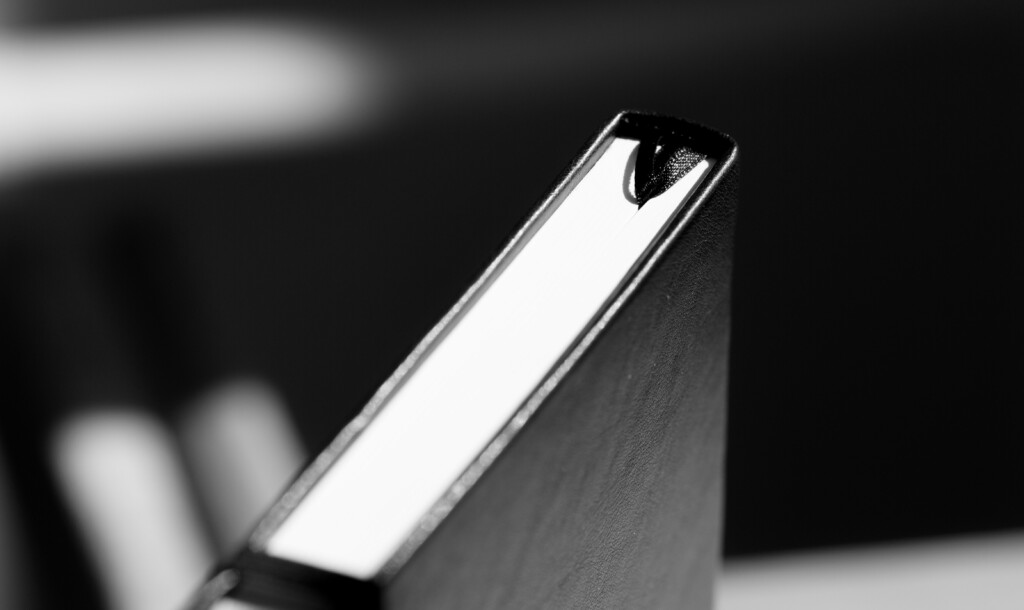 Planner with embossed cover detail and spiral binding, shown in black and white close-up.