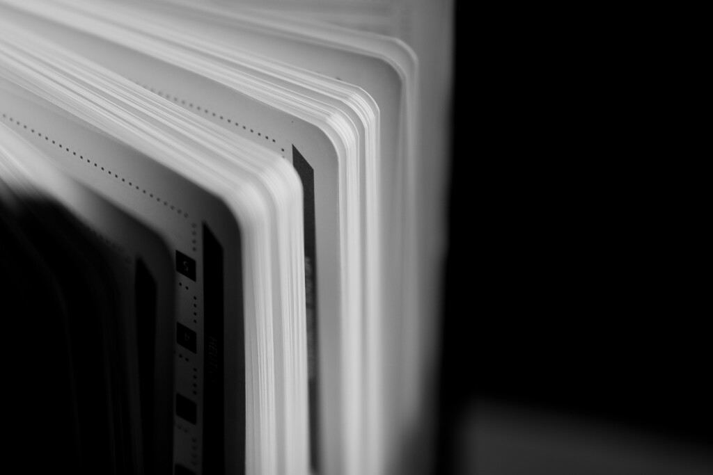 Stacked hardcover books with white spines and rounded edges, close-up of binding and cover detail.