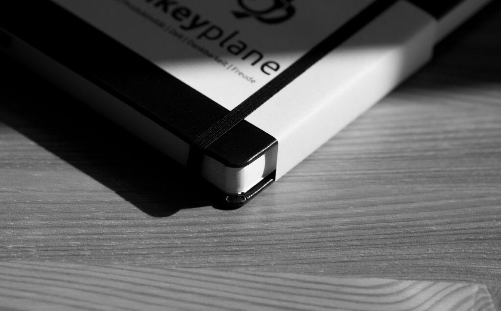 Hardcover book with black and white cover displayed at an angle on a wooden surface, showing the spine and binding detail.
