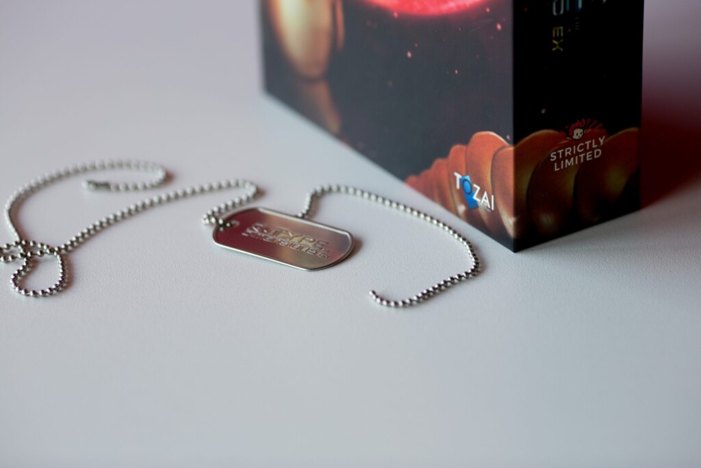 Metal dog tag pendant on beaded chain with limited edition branded box.