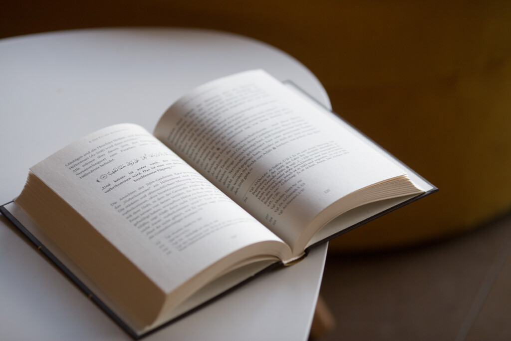 Open hardcover book with printed text pages on white surface.