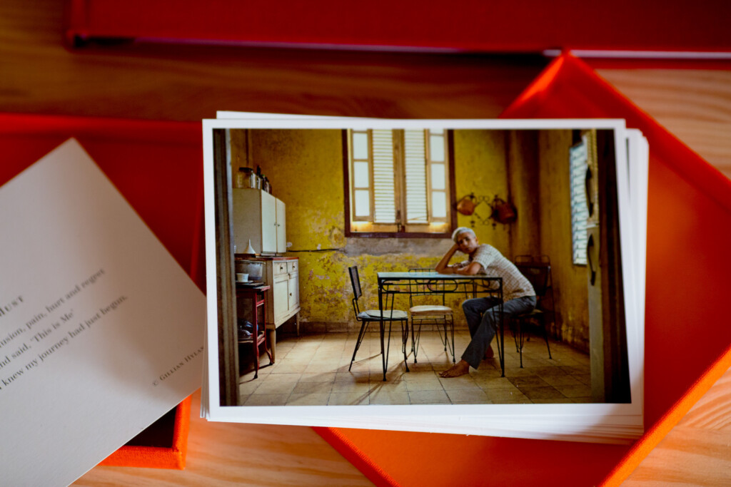 Printed photo album open to spread showing vintage kitchen interior photograph with yellow walls and retro furnishings.
