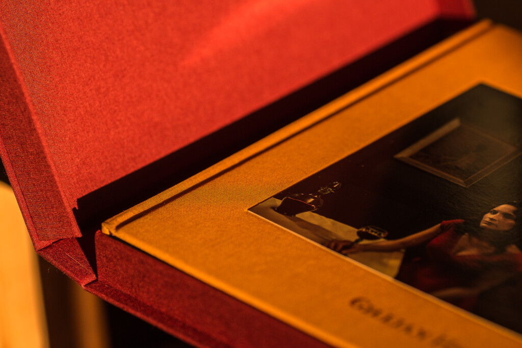 Close-up of red hardcover book with orange-edged pages and black ribbon bookmark.