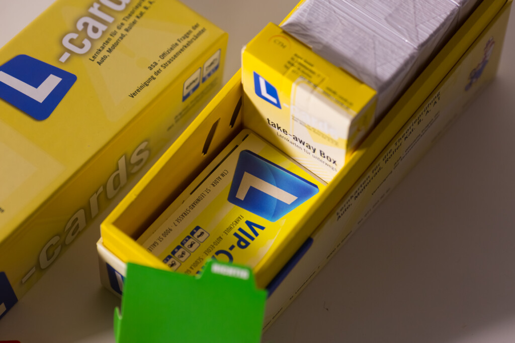 Yellow learning card box with blue logo, lid open showing stacked flashcards and white label on top card.