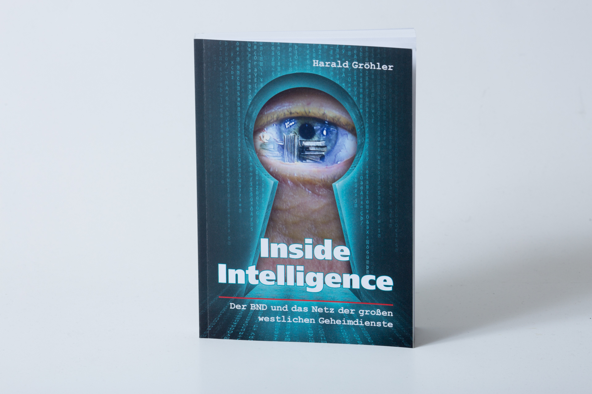 Hardcover book titled Inside Intelligence by Harald Gröbler with keyhole design showing digital cityscape reflection in the