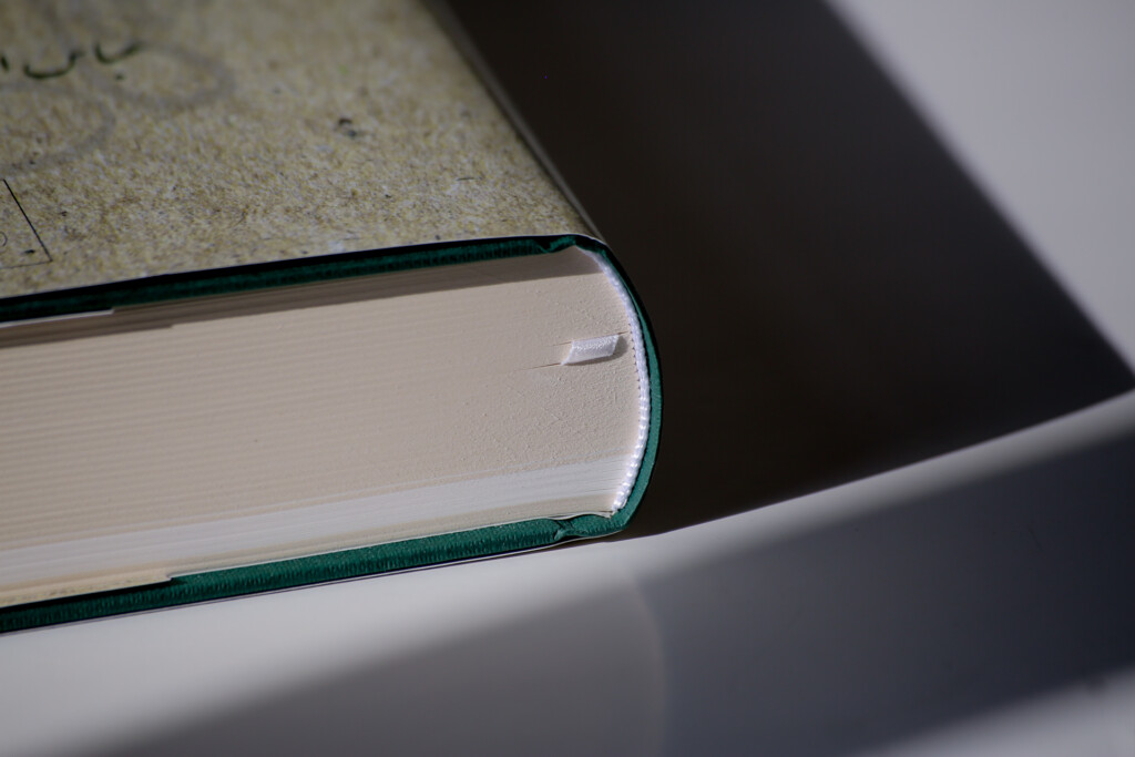 Hardcover book with green cloth binding and dust jacket, shown closed at an angle displaying the spine and page edges.