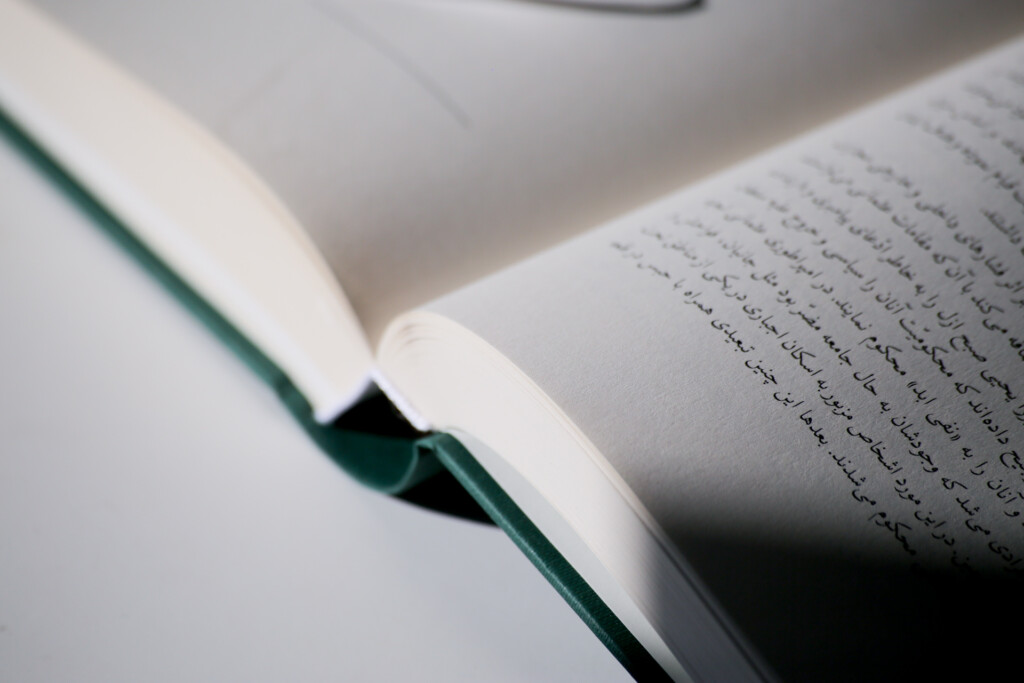Open hardcover book with green cloth binding and printed text visible on the right page.