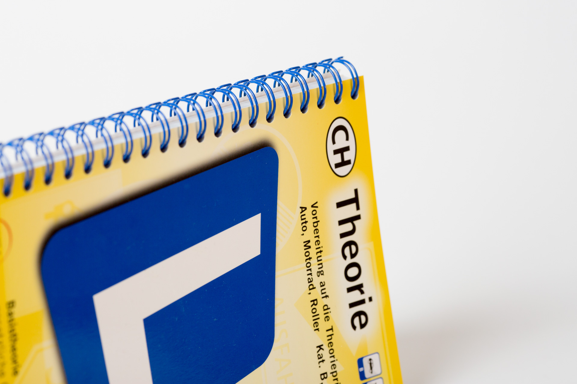 Wire-o bound notebook with yellow cover and blue spiral binding detail visible.