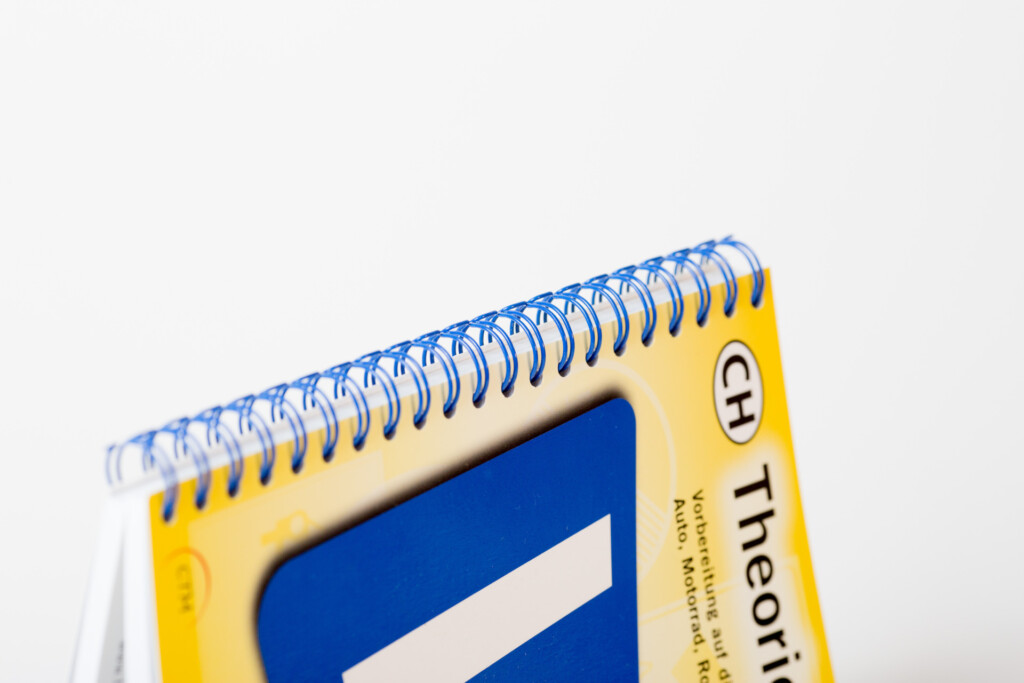 Spiral-bound notebook with yellow cover and blue interior panel, showing metal wire binding detail.