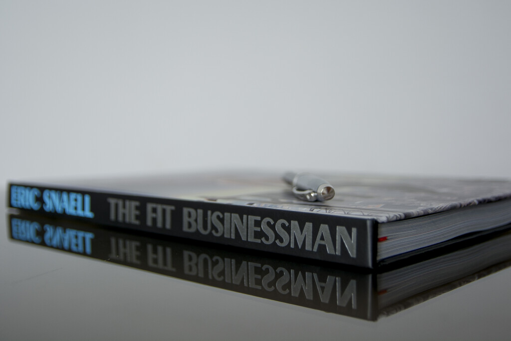 Two hardcover books stacked, with visible spines reading "The Fit Businessman" in blue and black lettering.