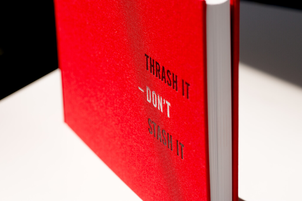Red hardcover book with embossed text reading "TRASH IT DON'T WISH IT" on the cover.