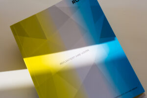 Robus LedGroup catalogue with yellow and blue geometric cover design, lit by white light to demonstrate reflective finish.