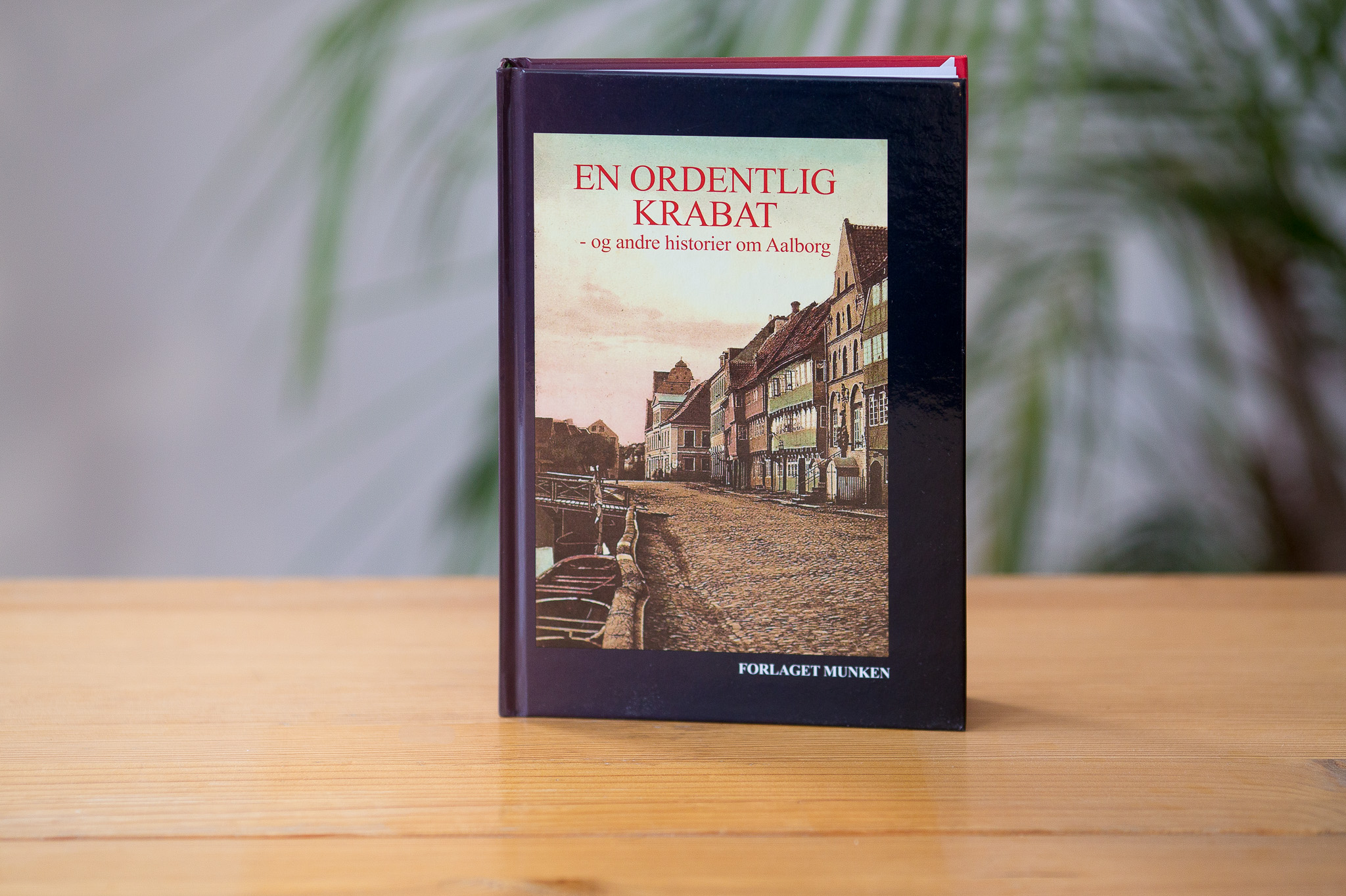 Hardcover book with dark blue cover featuring a historical street scene photograph and the title "EN ORDENTLIG KRABAT" in