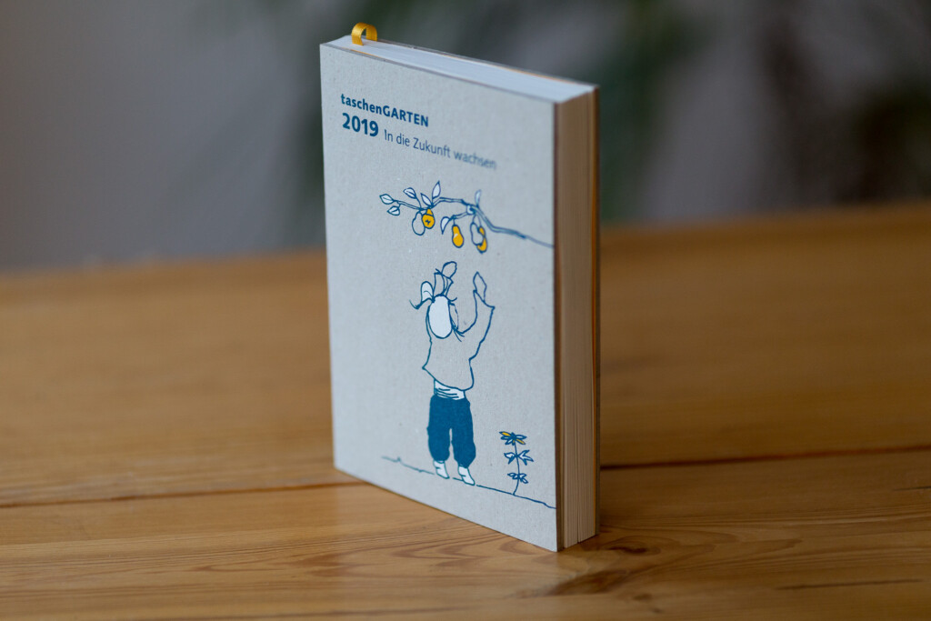 Paperback book with white cover featuring illustration of child figure, standing on wooden surface.