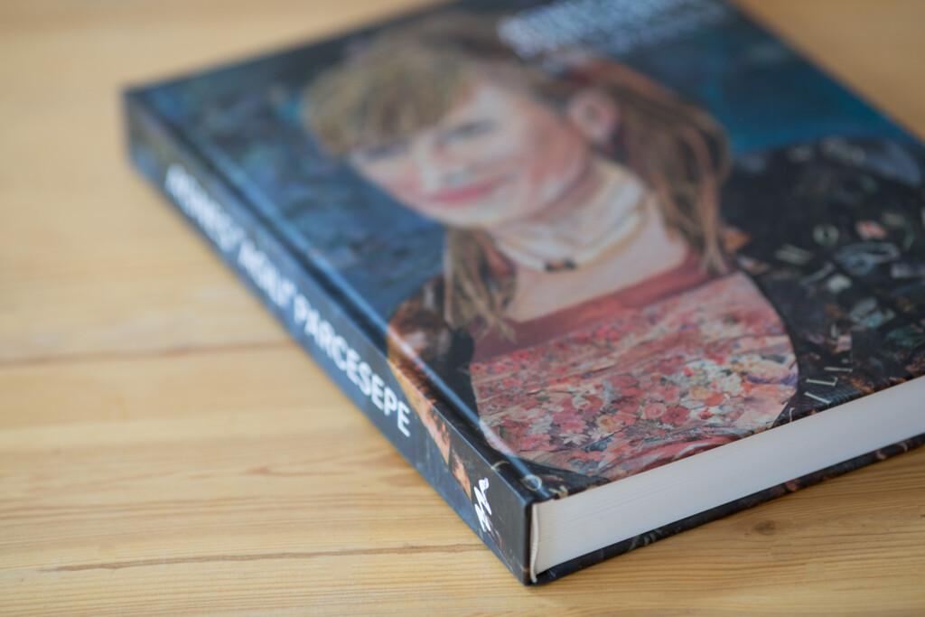 Hardcover book with blue spine displayed at an angle on a wooden surface, showing cover featuring a child's portrait and