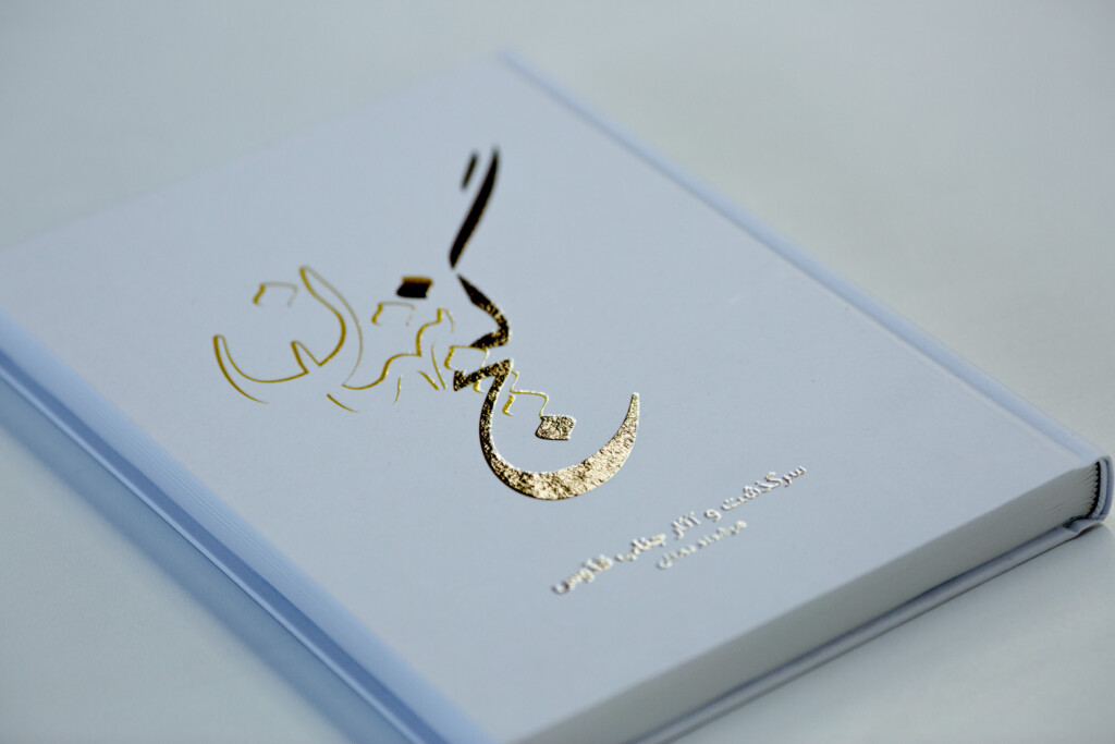 Case-bound book with gold and black foil-stamped Arabic script on light blue cover.