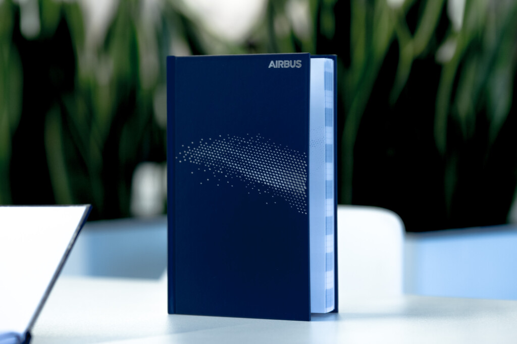 Navy blue hardback notebook with Airbus branding and white dotted wave design on cover.