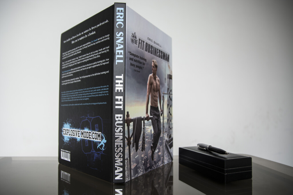 Hardcover book with spine reading "Eric Smaeil The Fit Businessman" displayed at an angle next to a black box on a grey