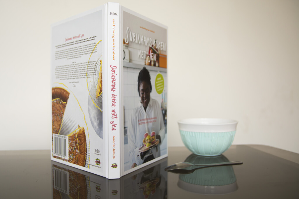 Hardcover cookery book displayed with its spine and back cover visible, alongside a light blue ceramic bowl.