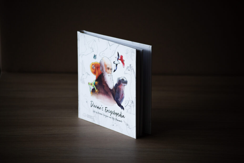 Hardcover book with illustrated cover featuring animals and a person, displayed at an angle on a wooden surface against a