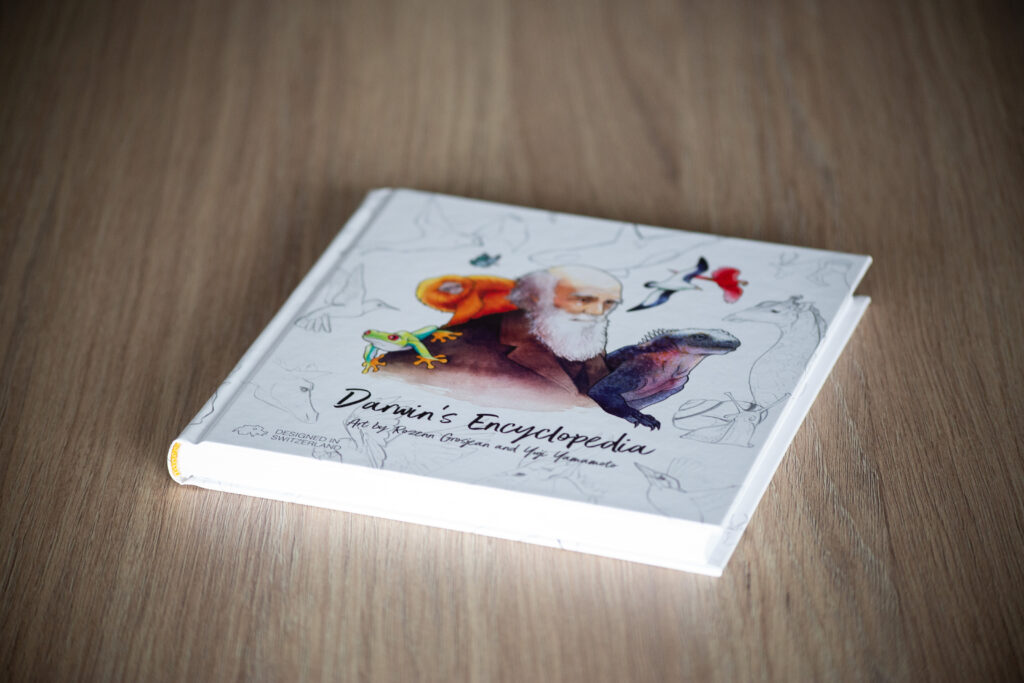 Hardcover book with white cover featuring watercolour illustrations of birds and botanical elements, titled "Darwin's